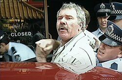 A man with a cool mustache is being arrested for eating a succulent Chinese meal