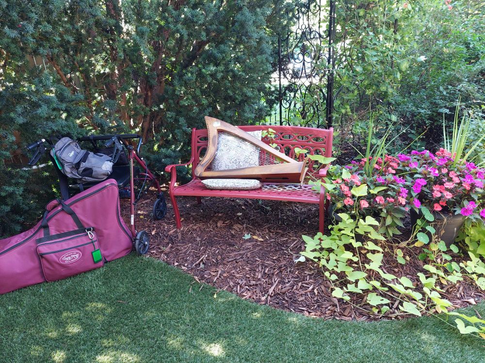 Rollator and harp case nearby, my harp Leannan on the bench from which we performed. All in a tiny corner grotto. 