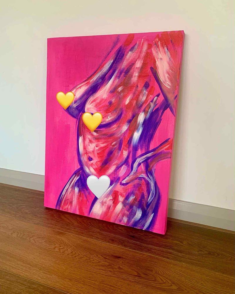 Expressive nude figure of a curvy woman in blue, red and white on a bright pink background. Painting is on a canvas leaning against a white wall on a wooden floor.