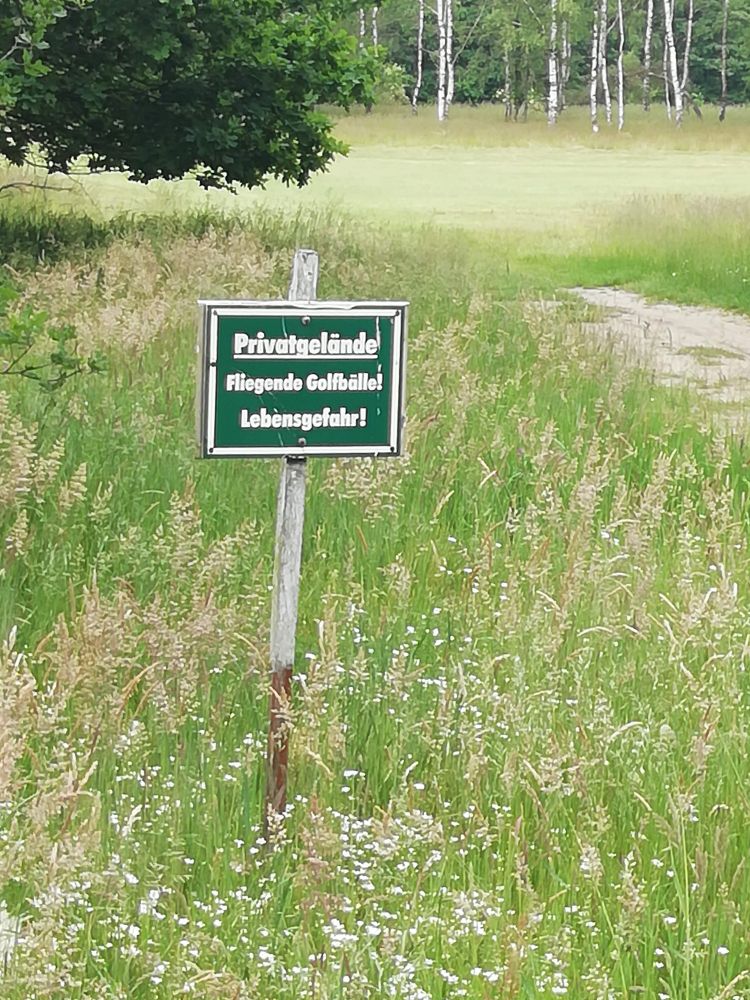 Schild: Fliegende Golfbälle! Lebensgefahr!