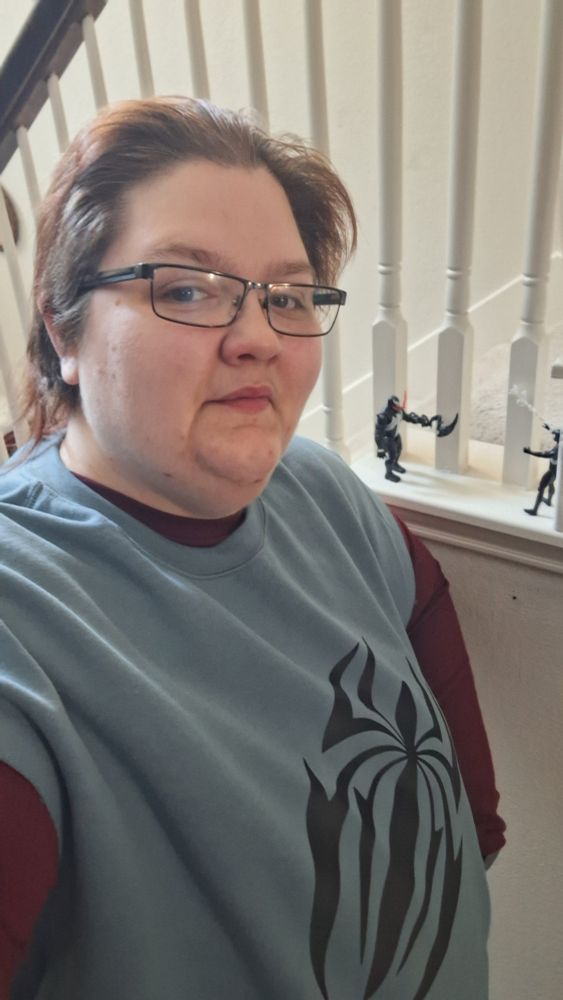 Femme person in blue sweatshirt with scarlet spider logo. Red shity underneath