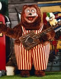 Terrifying animatronic bear in striped overalls, watching you eat bad pizza.