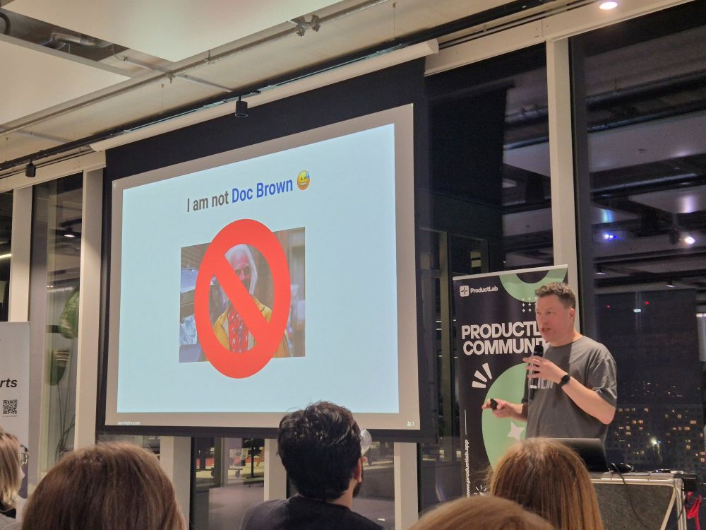 Jason Knight, during a presentation about 2025 product management predictions, standing in front of a slide with "I'm not Doc Brown", indicating that he's not, sadly, coming from the future. 
