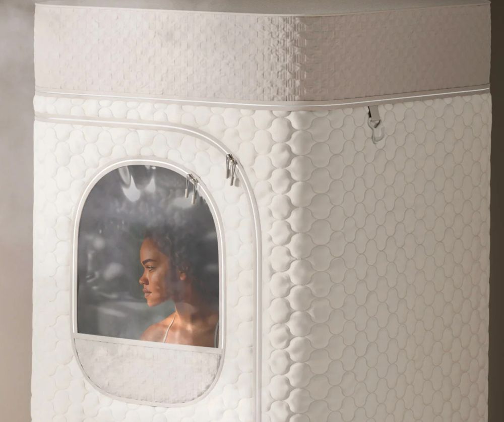 close-up of the at-home steam sauna tent. through a window you can see a woman poorly photoshopped into the sauna tent