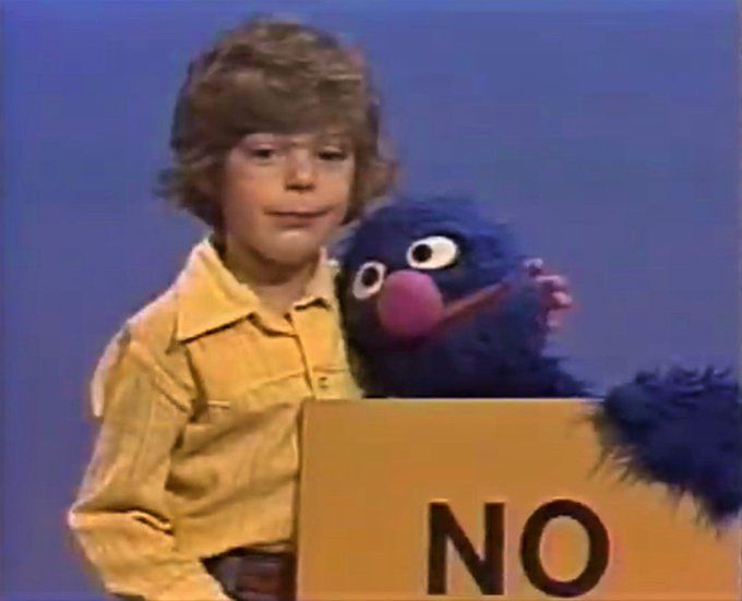 Grover and child holding "NO" sign 
