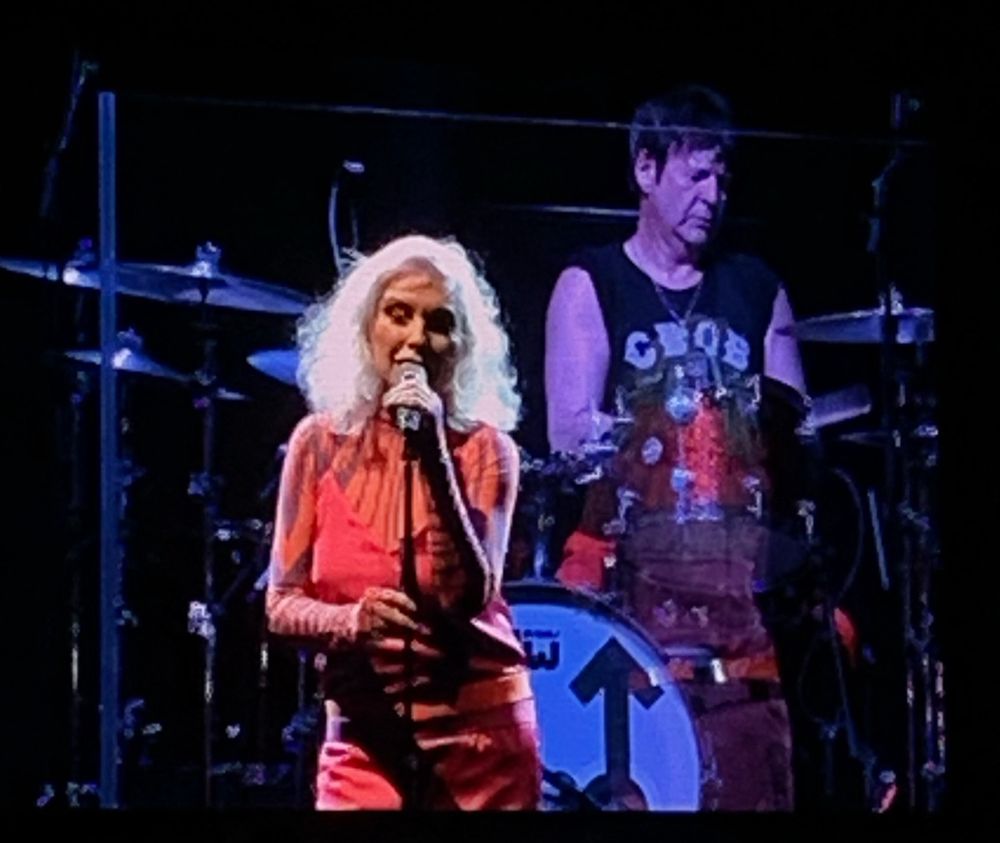 A photograph of Clem Burke playing the drums and Debbie Harry singing, Blondie concert, Glasgow May 2022