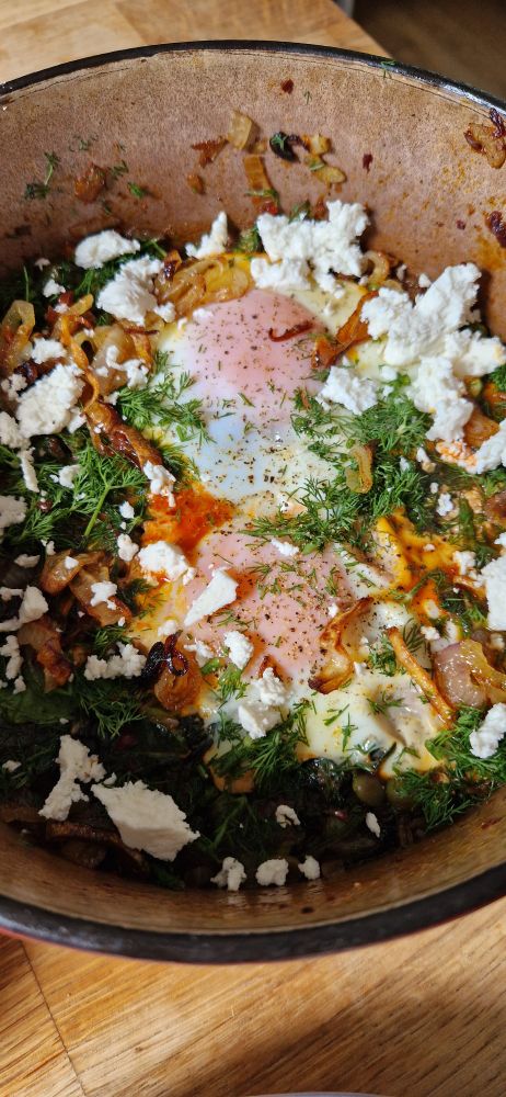 The eggs in the pan topped with crumbled feta cheese.
