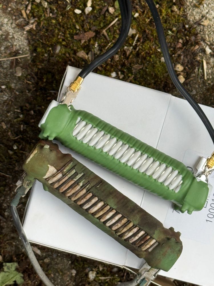 Zwei Vorwiderstände, ein alter und ein neuer. Der obere grüne Vorwiderstand ist der neue Ersatz, während der untere stark korrodierte und verschmutzte das alte, defekte Teil ist.

Die Vorwiderstände regeln die Gebläsestufen der Heizung/Lüftung. Der alte zeigt deutliche Korrosionsschäden und Verschmutzung, was typisch für diese Bauteile nach 20+ Jahren ist. Die charakteristischen Rillen/Lamellen sind bei beiden gut erkennbar - beim neuen sauber und funktionsfähig, beim alten durch Korrosion beeinträchtigt.

Ein klassisches Verschleißteil beim T4, das oft für Probleme mit der Gebläseregelung sorgt. Der Austausch ist relativ einfach und löst meist die Probleme mit ausgefallenen Gebläsestufen.