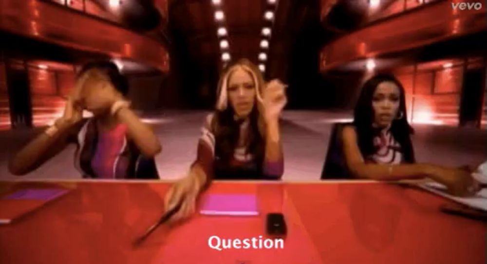 three women are sitting at a table and the word question is on the screen