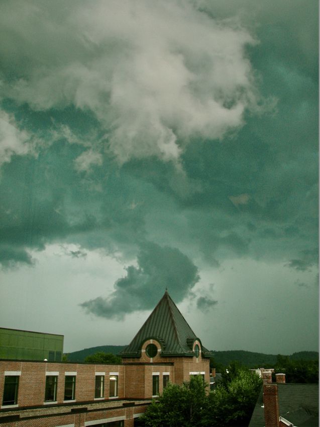 Photo of greenish storm clouds over a college campus.