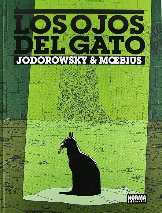 Cover for the graphic novel The Eyes of the Cat, from Jodorowsy and Moebius. A black cat is sitting at the center of the image, illuminated by a green light beam that falls from the sky. The environment looks empty, with some kind of technological rubble scattered on the floor.
