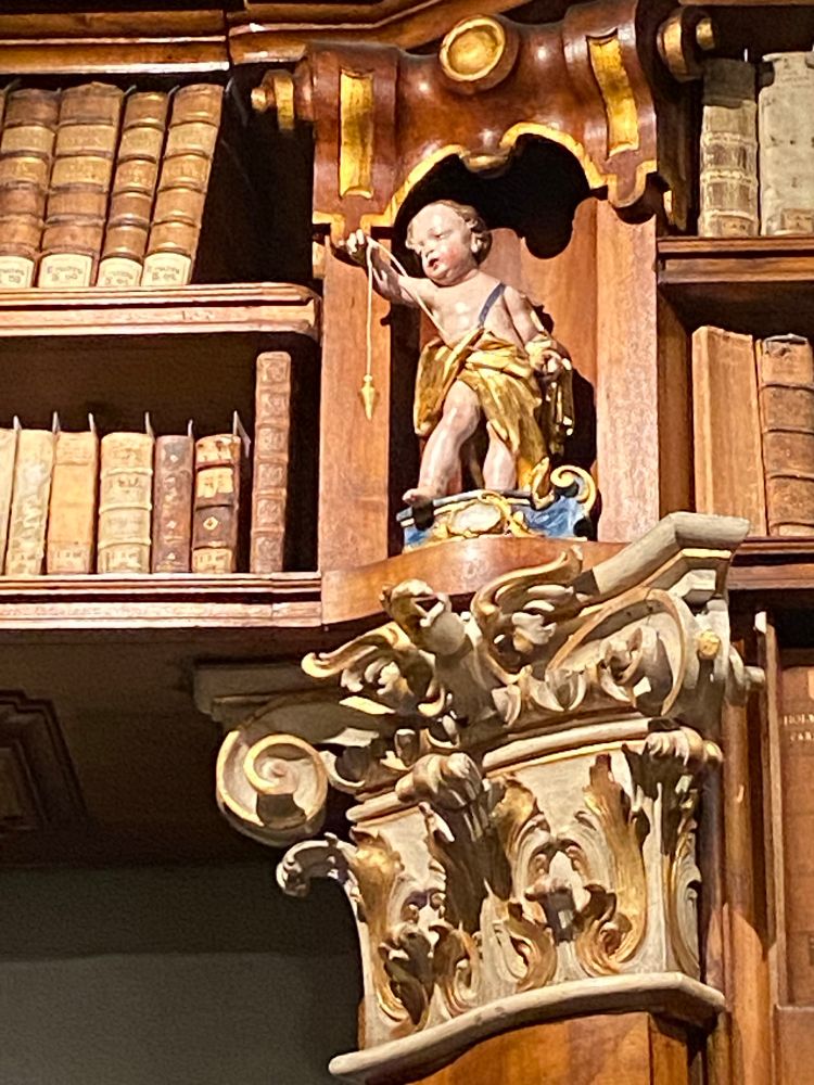 Picture of a cherub statue holding a plumb bob 
