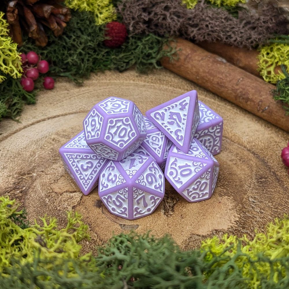 Pastel purple polyhedral dice with white engraved patterns