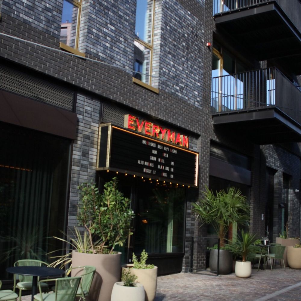 Everyman cinema entrance surrounded by large pot plants, tables and chairs