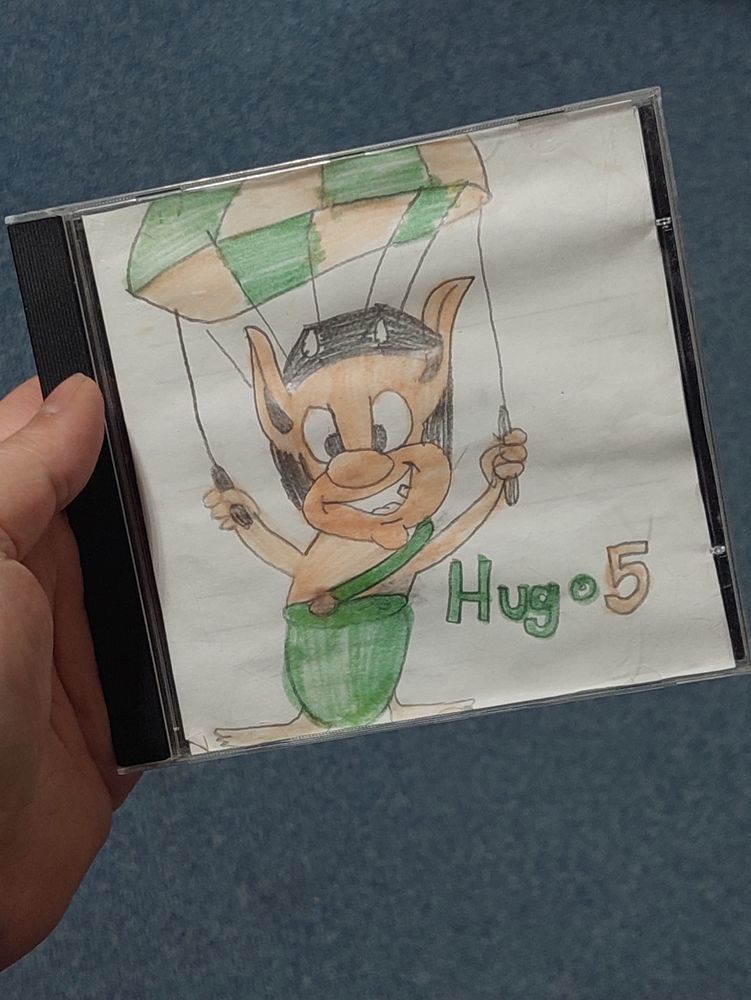 CD Hülle mit gezeichnetem Cover von einem Troll, der mit einem Fallschirm fliegt.