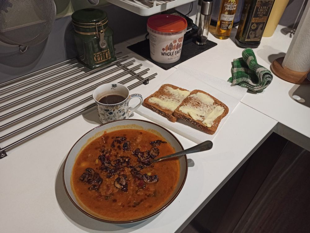 Bowl of homemade tomato dhal topped in garlic mushrooms, bread & butter. Coffee.