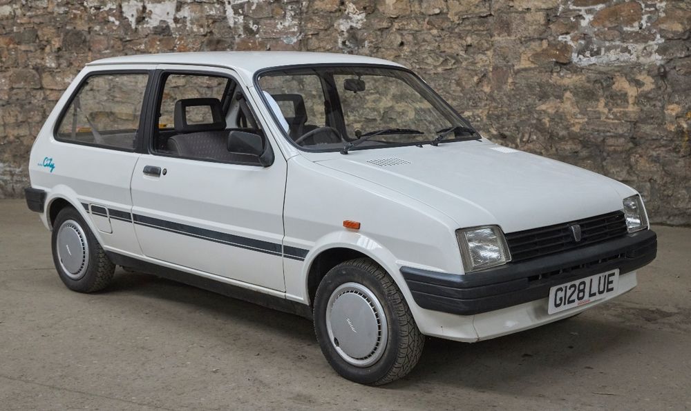 A small, white, 3 door car. 