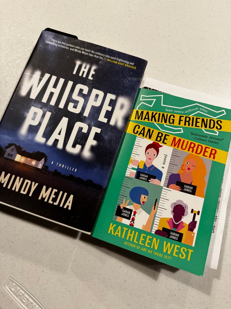 Two books. On the left is The Whisper Place by Mindy Mejia and on the right is Making Friends Can be Murder. The books are on a plain background. 
