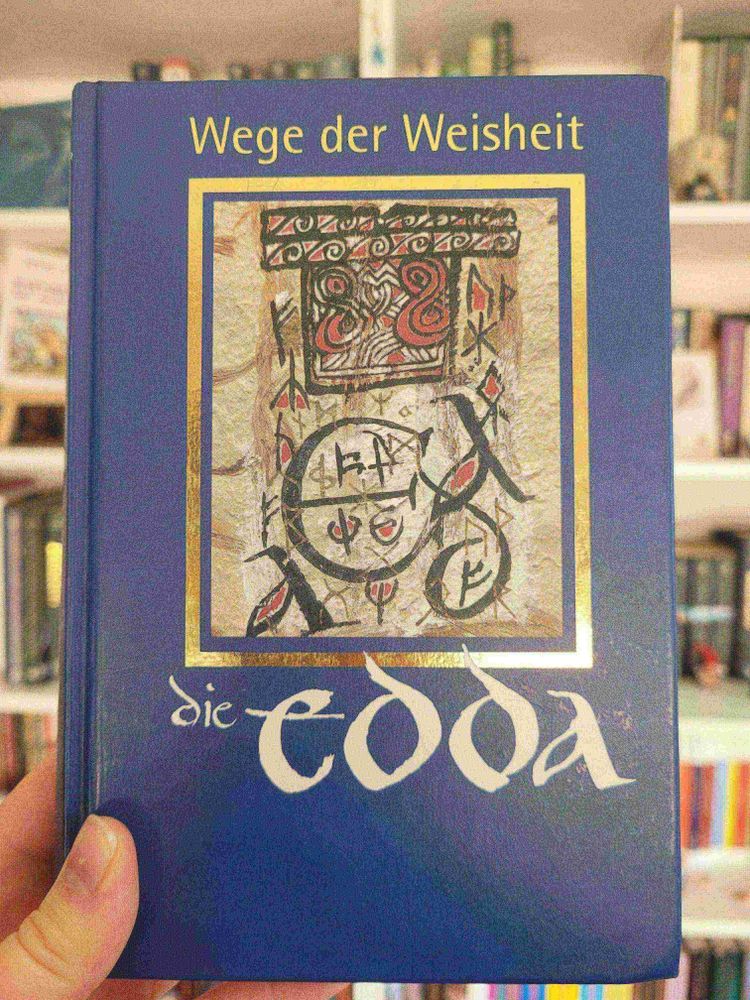 Foto einer Ausgabe der Edda vor einem Bücherregal