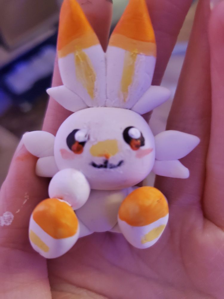 A tiny Scorbunny figure made of clay, and painted with acrylic paint.