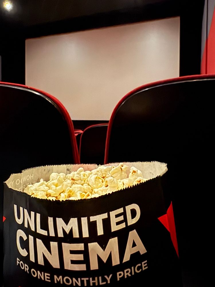 Photo taken of the inside of a cinema with a bag of popcorn 