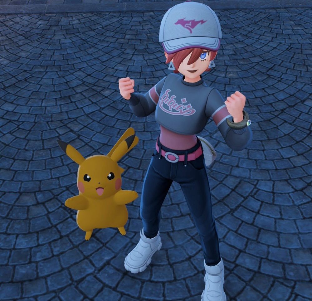 REN’s character from Pokemon Legends ZA wearing a grey and pink cropped shirt, denim pants and white sneakers stood doing a pose next to a shiny female pikachu 