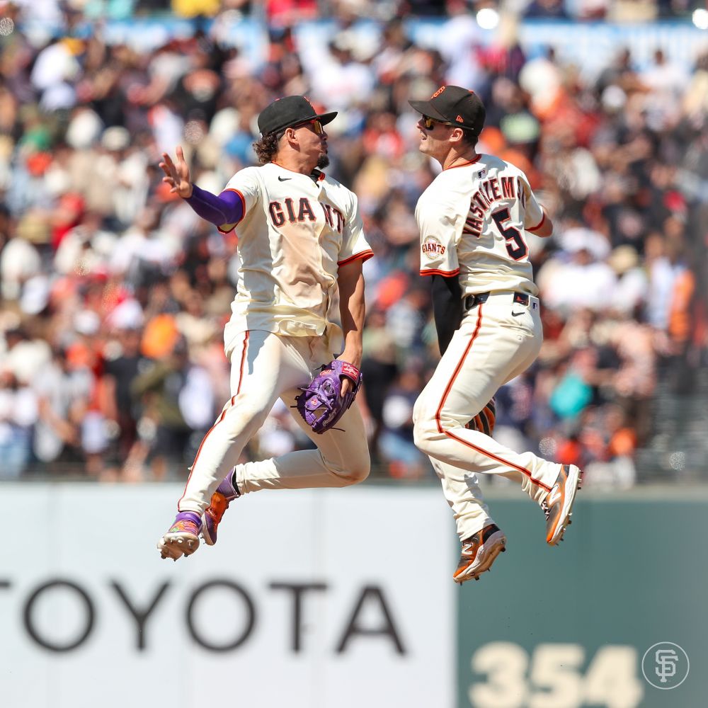Willy Adames and Mike Yastrzemski jump and high-five post game. 