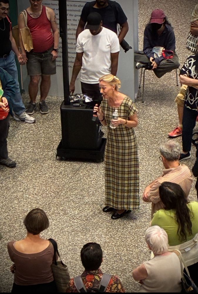 Sophia Jansson (niece of Moomins creator) in a brown and yellow striped dress, surrounded by an eclectic group of Brooklynites