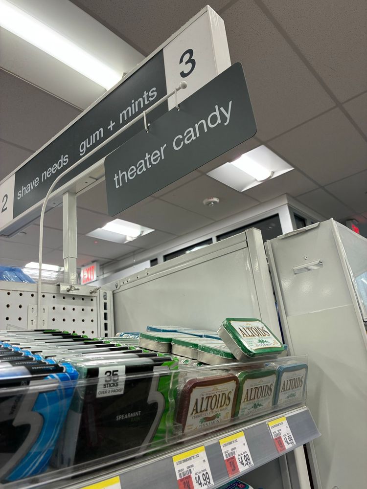An aisle with the sign “theater candy”