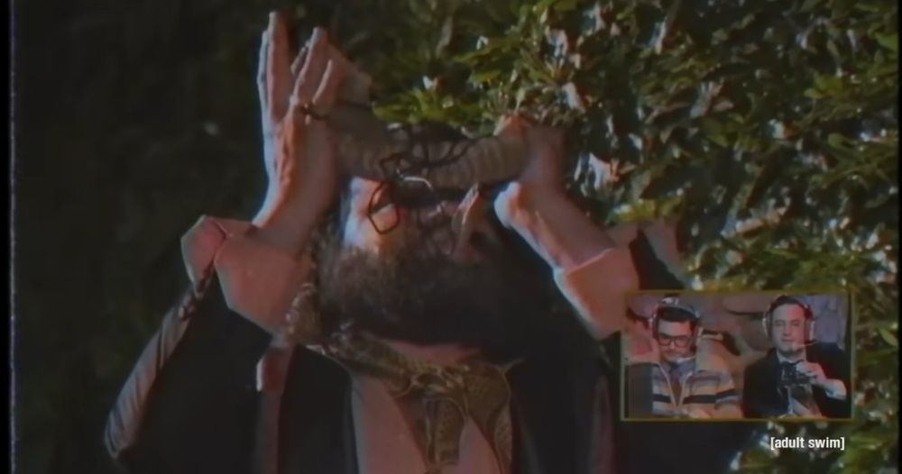 screenshot from LIVE AT THE NECROPOLIS: LORDS OF SYNTH

xangelix, seen from chest up, is raising his conch to heavens, continuing to blow

a small inset screen, at the bottom right side of the picture, shows commentators, edgar tangram (left, polyharmonics expert) and zedd centauri (right, octave collector)