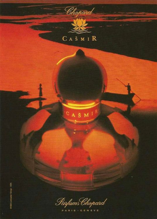 An old magazine ad for Casmir by Chopard. It’s high contrast black and orange with an image of the bottle in the center with a river at sunset in the background.