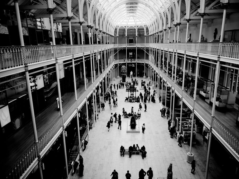 A picture from the highest gallery, looking down into the atrium of the national museum in Edinburgh towards the lighthouse lens on the ground floor. The is a slight vignette effect so the near parts of the photo are generally darker. If you look closely various gallery exhibits can be seen. 