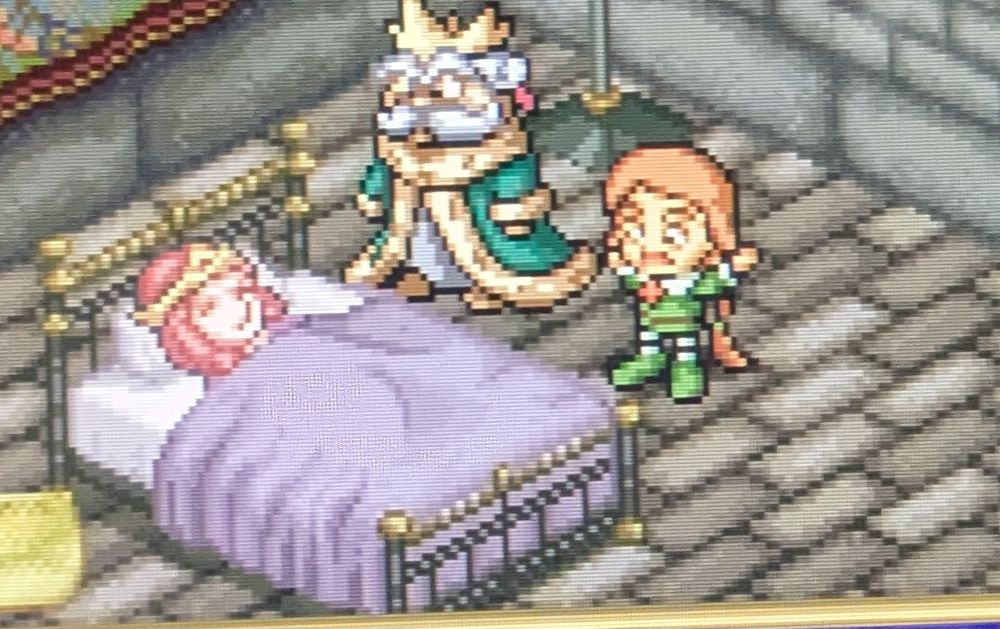 A poorly cropped screenshot of Popolocrois, the prince and his dad are in a room with a mysterious lady in a bed. The prince has a shocked face that is kinda hilarious.