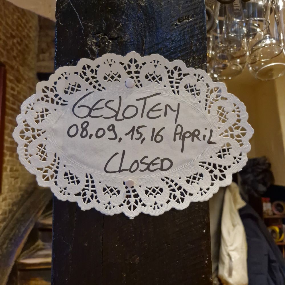 Paper doily notification of exceptional closing days at De Garre, Brugge: 8-9-15-16 April.