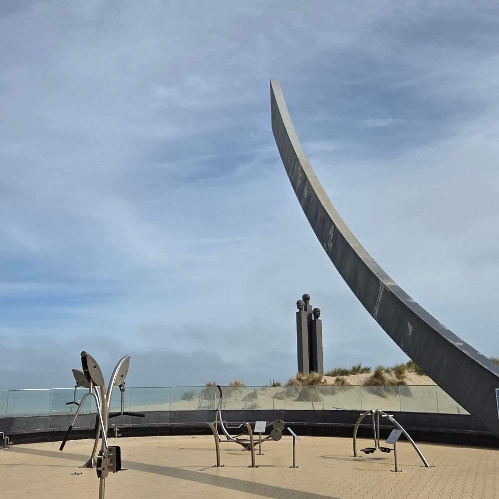 Sculpture on the beach at De Panne. Partly cloudy blue skies above.