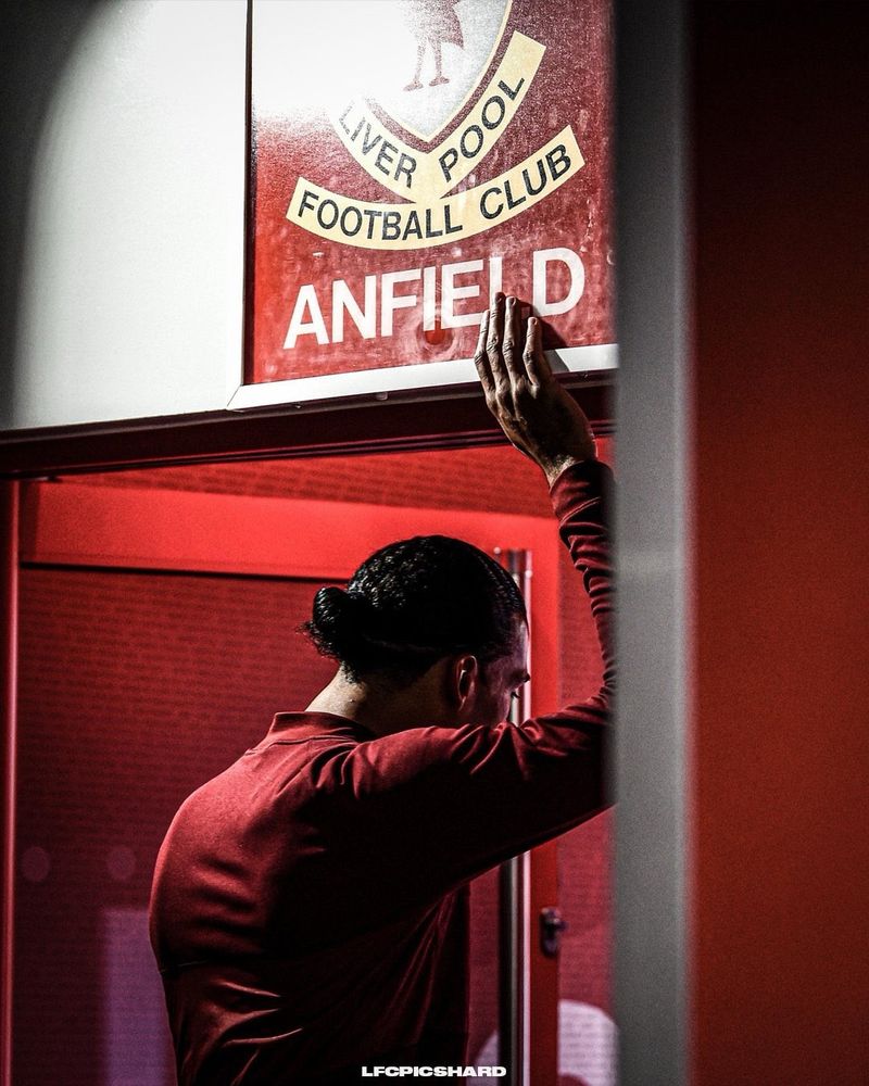 Virgil Van Dijk touches the “This is Anfield” sign as he heads into the pitch. 