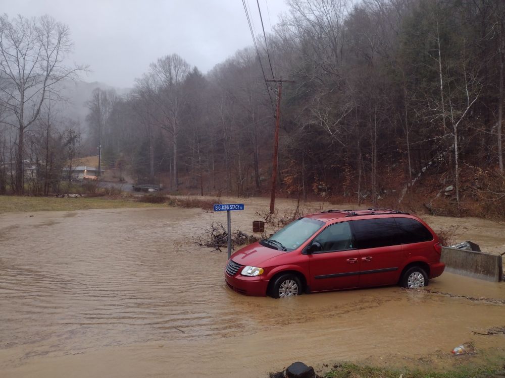 A van sits in flood waters. A river runs behind it. I dreamed of this particular scene ~20 years ago (minus the van)