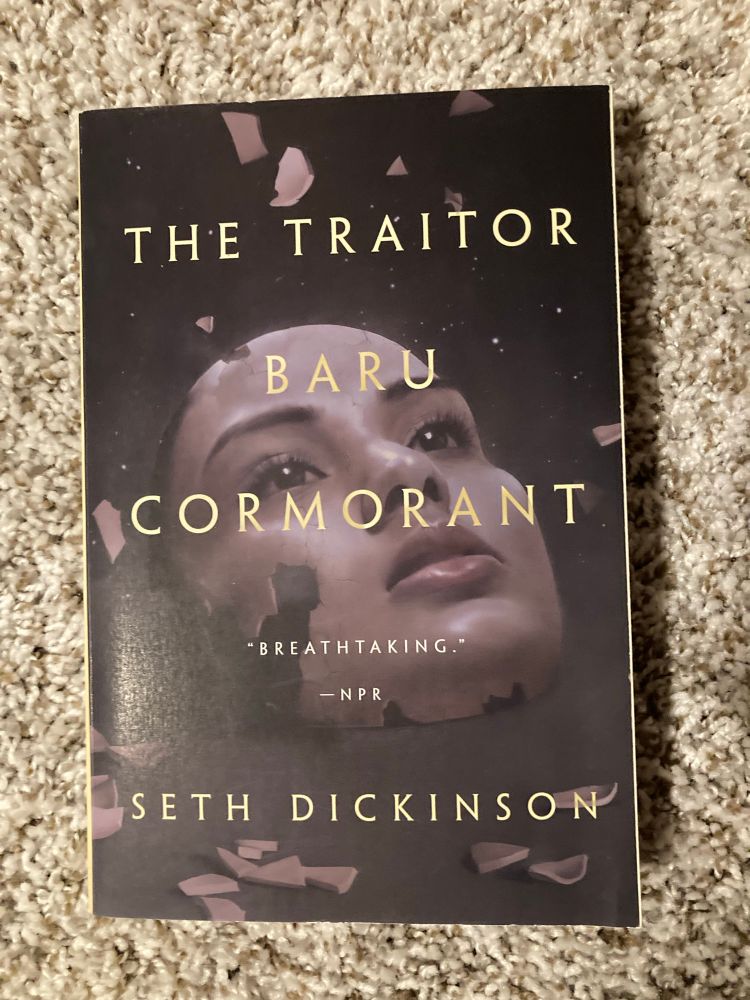 The cover of “The Trator Baru Cormorant” by Seth Dickinson, picturing a shattered female mask on a black background. 