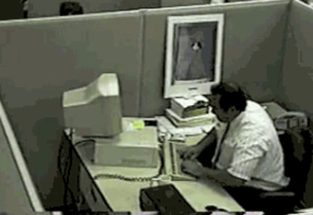 a man sits at a desk in front of a computer with a picture on it