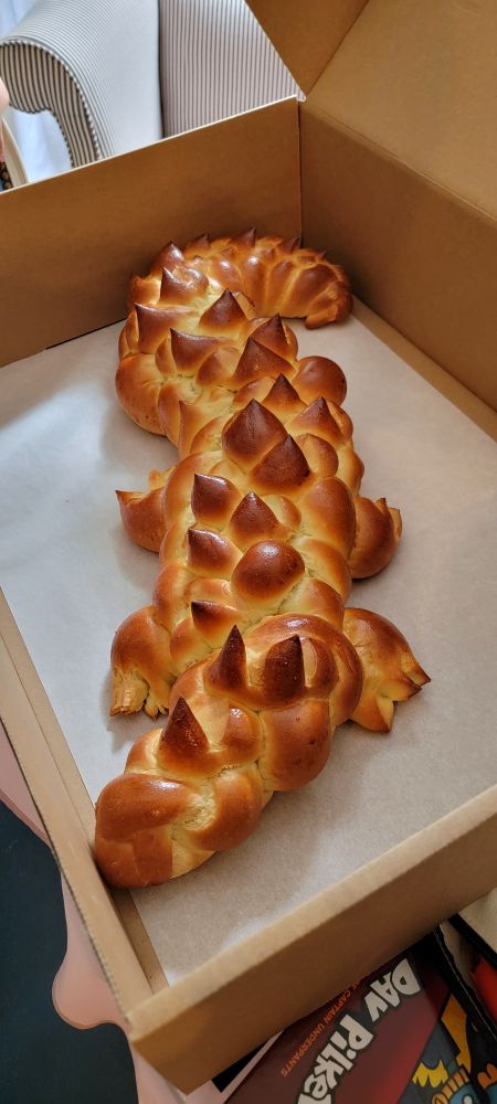 A loaf of challah bread with spikes and legs that resembles an alligator. 