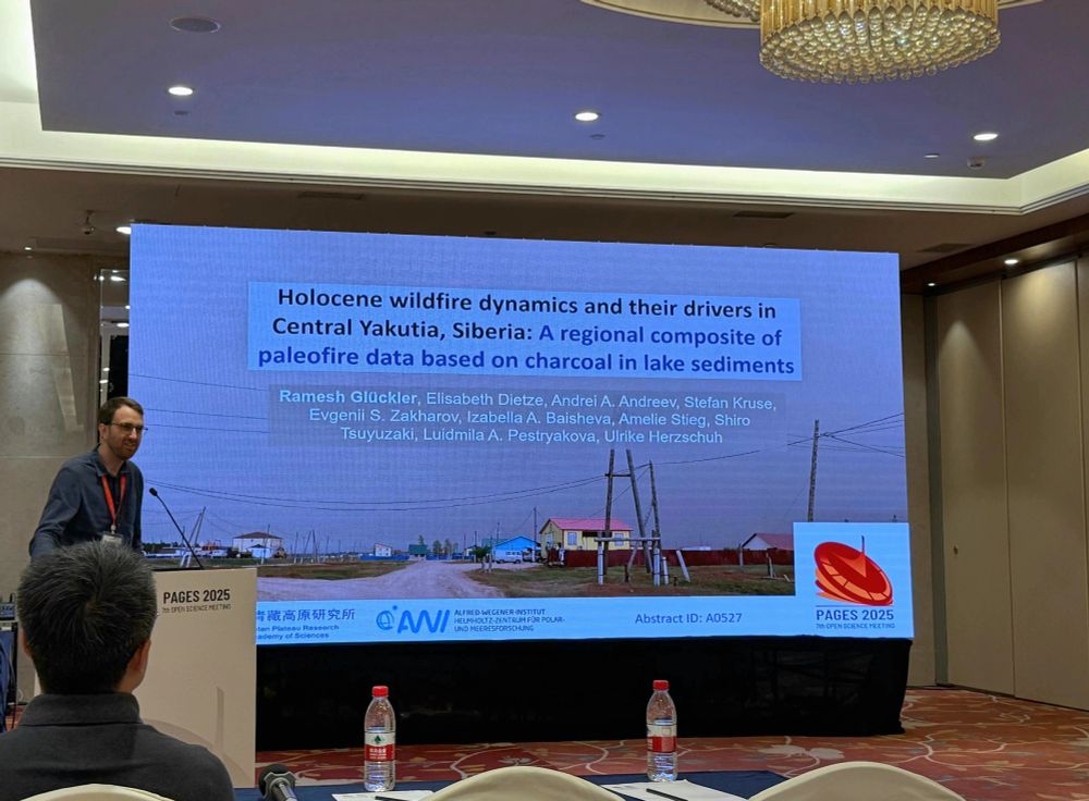 Me standing in front of a big screen showing the first slide of my conference presentation.