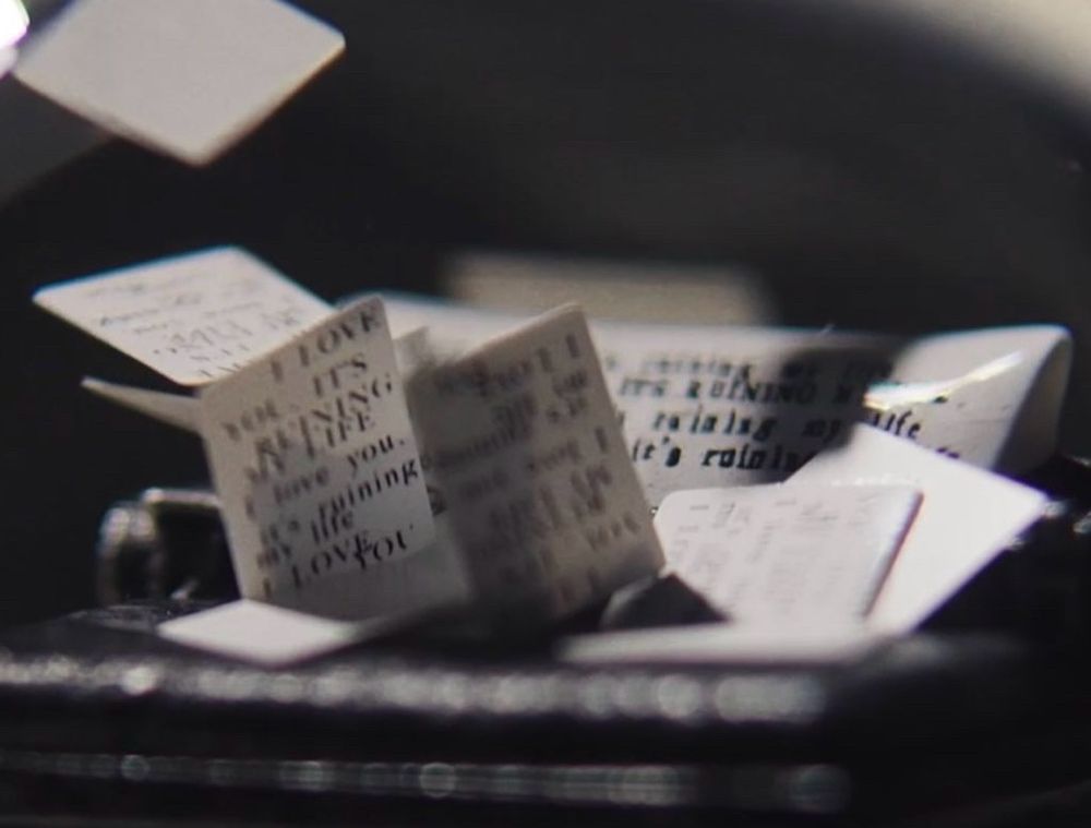 zoom in of the teeny tiny papers in the snowglobe with lyrics written on them