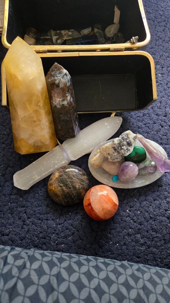 A collection of crystals and stones arranged in front of makeup case