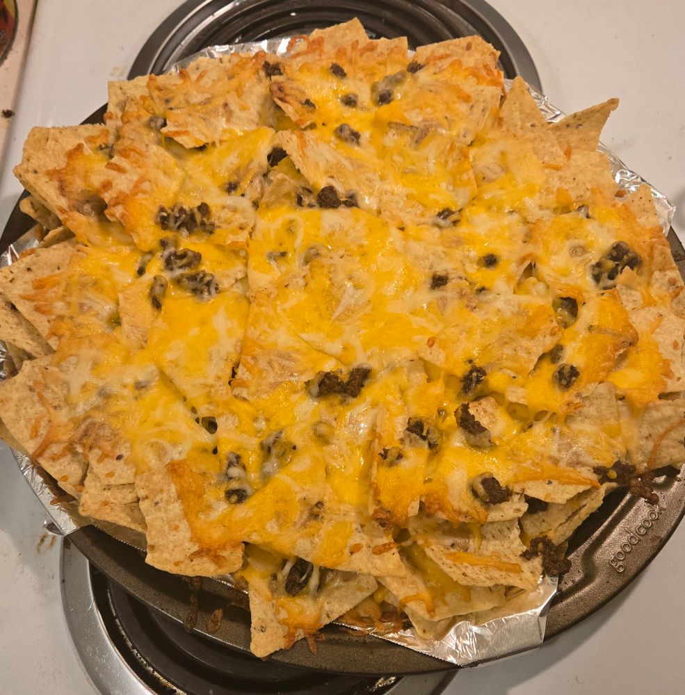 NACHOS!!! A big round baking tray with three layers of meat, cheese, and corn tortilla chips.
