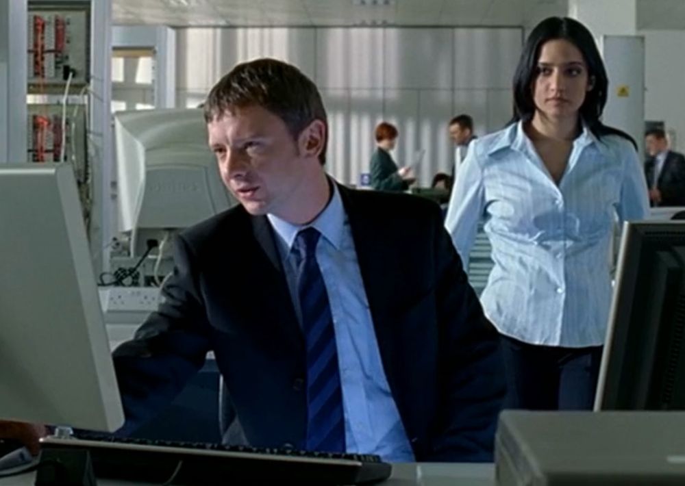 An office scene from Life On Mars, featuring John Simm and Archie Panjabi.