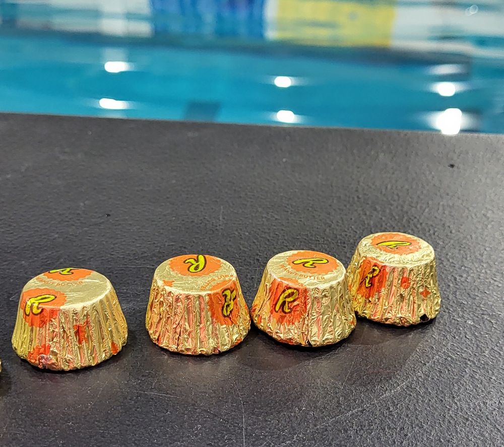 4 reeces cups on a table in front of the pool