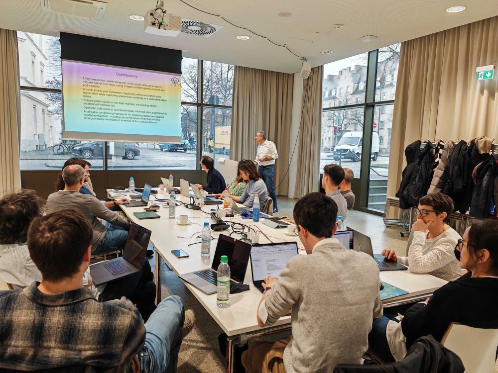 Researchers sitting around a table during workshop day.
