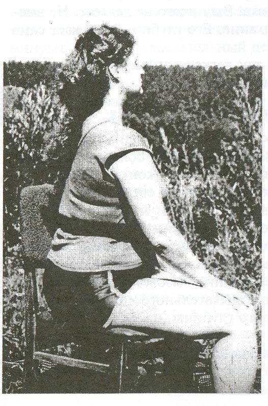 Buteyko Breathing Exercise number 1, sitting pose, sitting very upright on the corner of a dinning chair with hands rested on knees. Black and with photo of Ludmila Sokolskaya wife of Buteyko Biographer Sergey Altukhov.