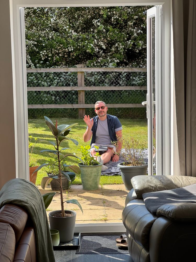 View of me sitting on the grass in the garden through the patio doors