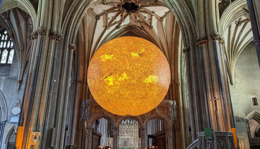 The model of the sun from the Helios art project, hanging in the columned nave of Bristol cathedral